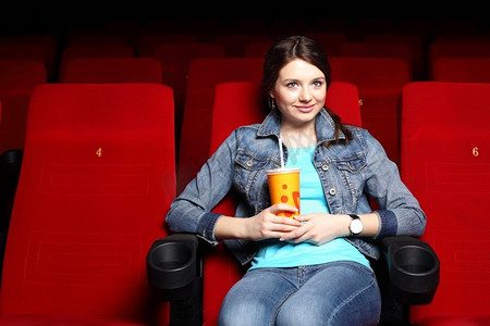 年轻女孩坐在电影院里看电影