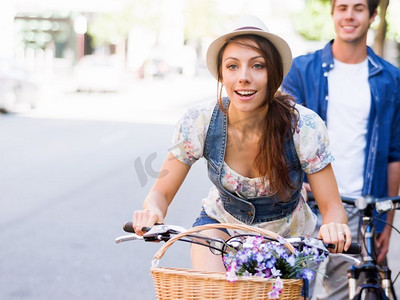 骑自行车的美女。美丽的年轻女子在城市里骑自行车