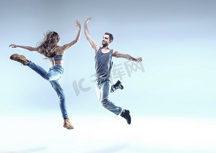 霹雳火秦明摄影照片_两个年轻的霹雳舞者在一个跳跃的姿势