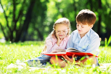 姐姐和哥哥在公园里看书。夏季周末户外活动