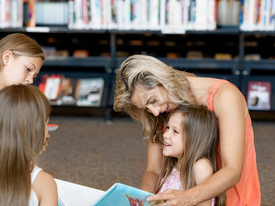 小女孩与他们的母亲在图书馆看书。我们爱读书