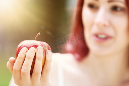 拿着苹果的女孩。夏令营里拿着红苹果的女孩肖像