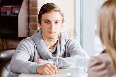 约会中的情侣。咖啡馆里，一位年轻男子和女孩坐在一起