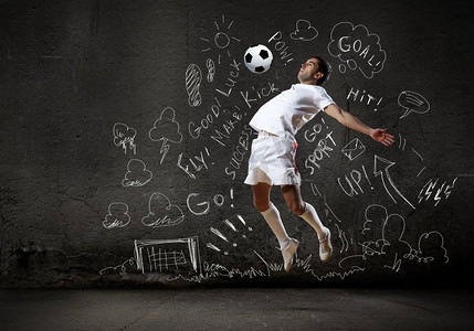 素描球摄影照片_游戏策略。足球运动员在跳跃击球，背景是素描