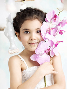 黑发小女孩手里拿着一朵五颜六色的花