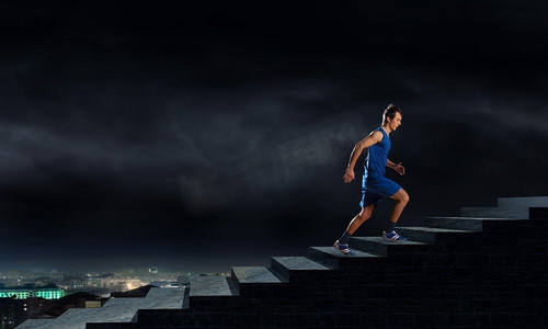 奔跑的运动员。身穿蓝色衣服的年轻男运动员在户外跑步