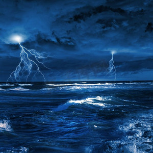 夜间大海摄影照片_海上有雷雨。夜间狂风暴雨的大海，波涛汹涌，闪电闪电