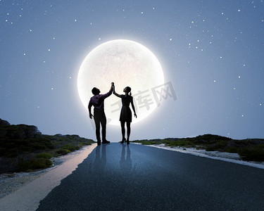 浪漫的约会。背景大月亮映衬下的情侣剪影