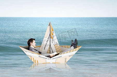 商人在纸做的船。成功的商人在金融海洋中的纸船上航行