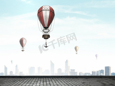 浮空器摄影照片_浮空器在城市上空飞行。五颜六色的浮空器飞行在晴朗的天空上面现代城市