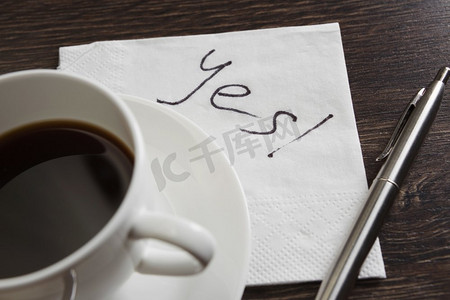 是的，在餐巾纸上回答。是的留言写在餐巾和咖啡杯上的木桌上