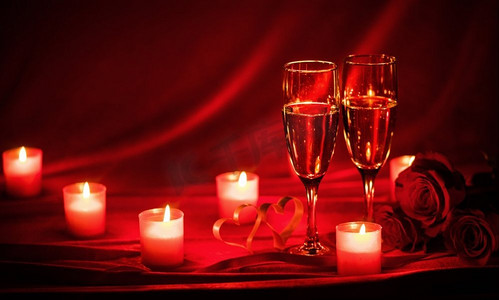 情人节庆祝活动，红丝绸上的香槟、蜡烛、玫瑰和红心