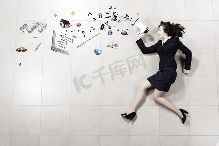 女发言人。滑稽的女实业家躺在地板拿着扩音器的女实业家
