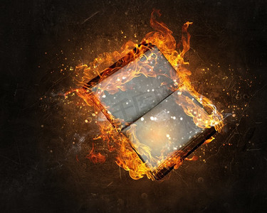白纸黑字的书着火了。书籍在黑暗的背景下被大火焚烧