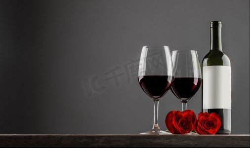 红色心形摄影照片_情人节，两个玻璃杯和一瓶红酒，心形玫瑰