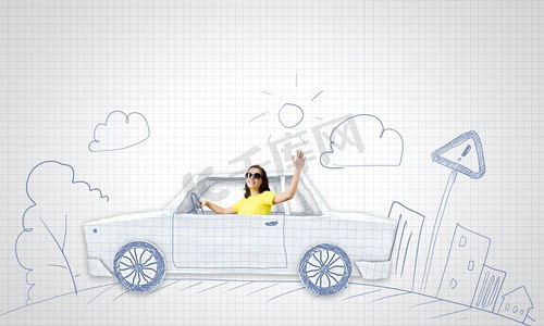 汽车行驶。一位年轻女子骑着一辆纸制的汽车