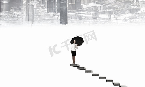撑着伞的女人。年轻漂亮的女商人穿着西装，撑着黑色的雨伞