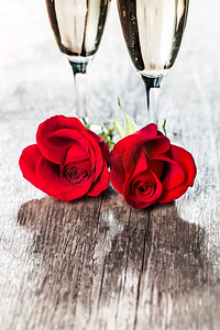 香槟和玫瑰香槟和红玫瑰在木背景