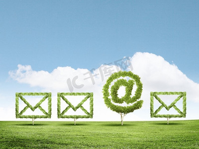 植物图标摄影照片_电子邮件概念。形状像电子邮件标志的绿色植物的概念图像