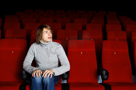 坐在电影院里看电影的年轻人