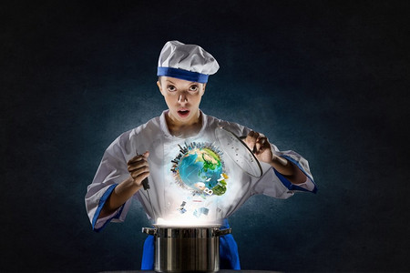 她是厨师的魔术师。漂亮的女人戴着帽子和围裙做饭，在锅上施展魔力。这张图片的要素由美国宇航局提供
