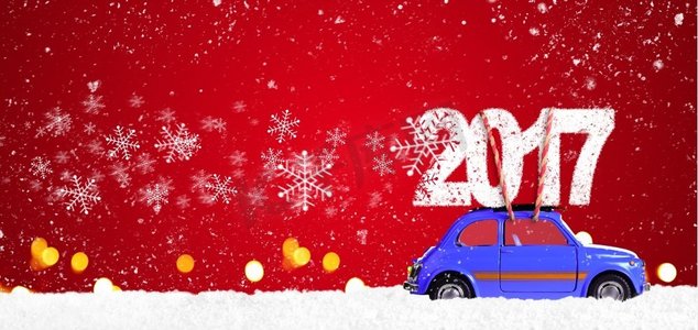 带有圣诞礼物的复古玩具车。蓝色复古玩具车在喜庆的红色背景下传递2017年圣诞节或新年