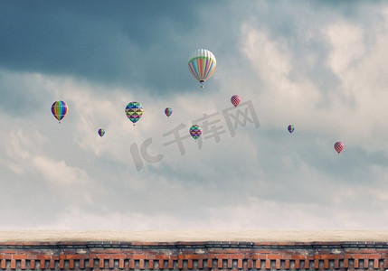 腊八免费粥摄影照片_会飞的浮空器。五颜六色的气球在灰色的天空中高高飘扬