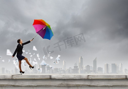带伞的女人走在屋顶的年轻女商人与五颜六色的伞