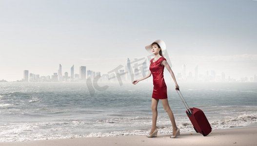 穿红衣服的女人。年轻女子穿着红色连衣裙，背着红色行李箱