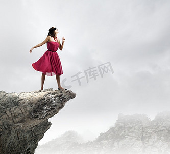 蒙着眼睛的女人。站在岩石边上的一位红衣女子