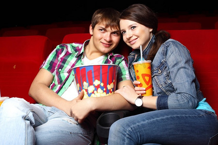 年轻夫妇坐在电影院里看电影