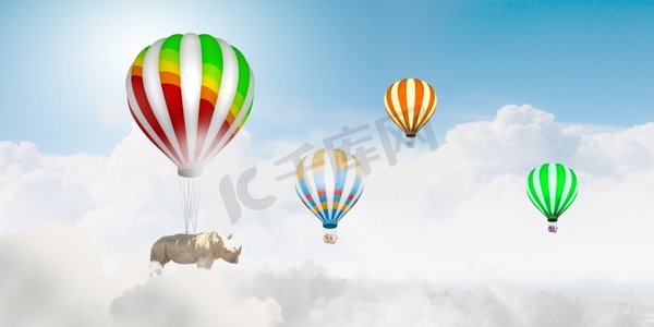 浮空器摄影照片_会飞的犀牛。犀牛坐在五颜六色的浮空器上高空飞翔