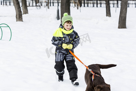 朋友友摄影照片_学龄儿童与狗在冬季公园。我和我最好的朋友