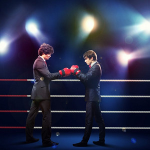 男人打拳摄影照片_两个年轻的商人在打拳击。两个年轻的商人在黑暗的背景下打拳。概念拼贴