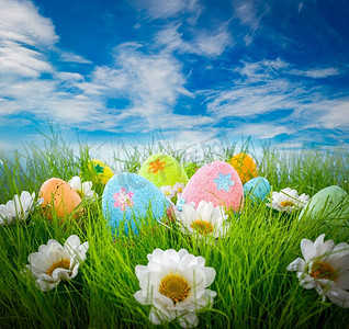 蓝天背景下草地上装饰的复活节彩蛋