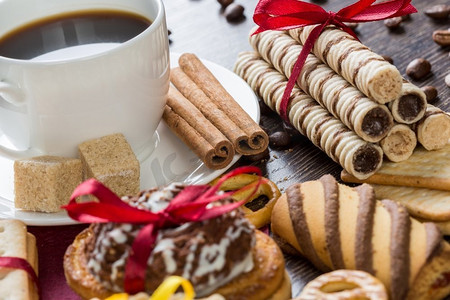 桌子上有饼干和咖啡。桌子上有各式饼干和糖果以及一杯咖啡