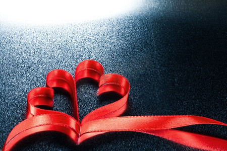 红色心形带摄影照片_两颗心形的丝带。两个红色丝带心形，金属背景，带复印空间