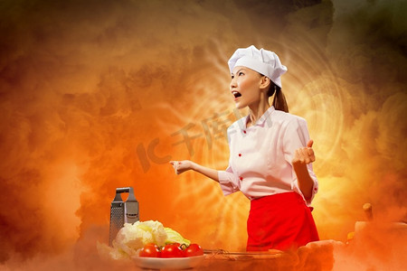 疯狂工作摄影照片_亚洲女厨师在愤怒。愤怒的亚洲女性厨师反对与闪耀效果的颜色背景