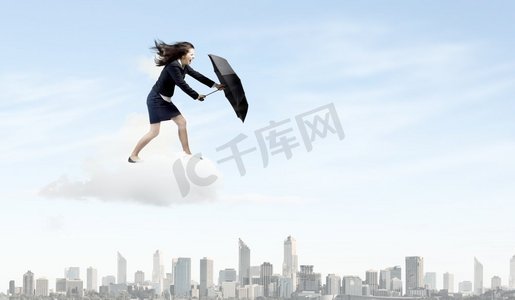 商业上的挑战。年轻坚定的女商人走在强风