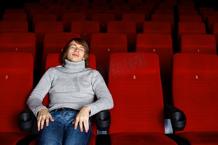 坐在电影院里看电影的年轻人