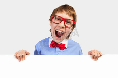 戴红眼镜的男孩拿着白色方块。小男孩笑着抱着白色方块的形象。刊登广告的地点