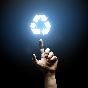 绿色手指箭头摄影照片_回收概念。人类的手用手指指向回收符号
