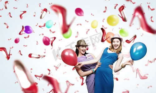 准备一个很棒的派对。两名年轻女子身穿休闲服，手持彩色气球庆祝