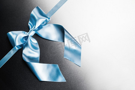 蓝色礼物摄影照片_蓝色丝带金属蝴蝶结。蓝色丝带蝴蝶结在金属背景与白色复制空间