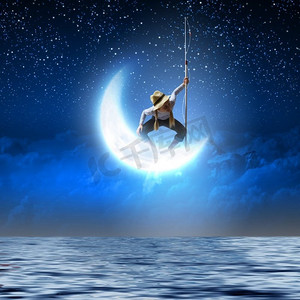 小渔夫。拿着钓鱼杆站在月球上的可爱女孩