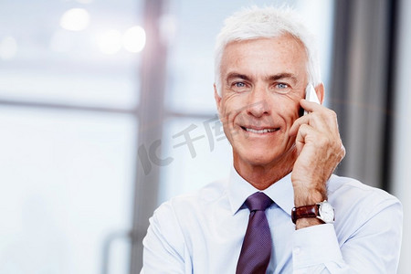 一位商人坐在办公室的电脑前打电话。保持联系和联系