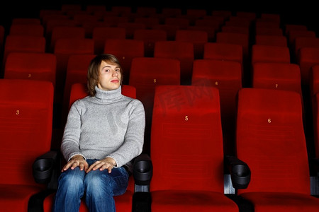 看电影摄影照片_坐在电影院里看电影的年轻人