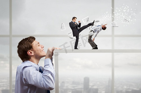 商人从桌子底下看着两个打架的同事