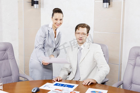 年轻漂亮的秘书向老板展示商业文件。办公室工作时刻