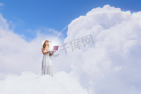 使用笔记本电脑的女士。站在云端使用笔记本电脑的年轻女士